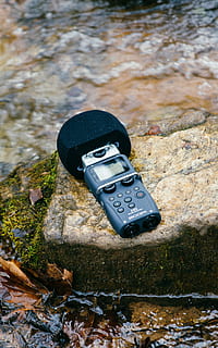 sort, digital, trådløs, mikrofon, mossy rock, apparat, klippe, teknologi, flod, flodbred, dag, natur, høj vinkel visning, ingen mennesker, vand, udendørs, solid, rock-objekt, fokus på forgrunden, jord, sollys, sort farve, sø, tæt på, Mark, sko, skønhed i naturen, plante, personlige tilbehør, 4K, CC0, offentligt domæne, royaltyfrie