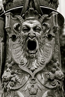 grå betongskulptur, gotisk, ansikt, jern, gargoyle, maske, øyne, svart, grimase, skummelt, skulptur, arkitektur, statue, nærbilde, representasjon, ingen folk, kunst og Håndverk, dag, kreativitet, håndverket, carving håndverk produkt, menneskelig representasjon, mønster, metall, utendørs, detalj, antropomorfe, fokusere på forgrunnen, gammel, utsmykkede, utskjæring, munnen åpen, blomstermønster, 4K, CC0, offentlig domene, opphavsrett gratis