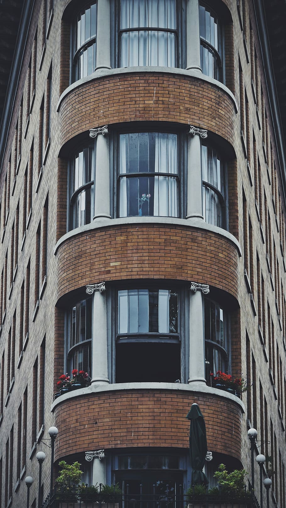 marró, blanc, concret, edifici, vermell, flors de pètals, balcó, edifici de maó, durant el dia, finestra, maó, arquitectura, paret, hotel, façana, simètric, vell, vintage, pis, exterior de l'edifici, estructura construïda, vista d’angle baix, ciutat, cap gent, dia, a l'aire lliure, barri residencial, vidre - material, apartament, naturalesa, marc complet, arc, vida de ciutat, reflexió, fons, 4K