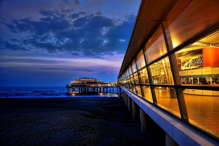 clar, paret de vidre, cos, aigua, scheveningen, hivern, oceà, arquitectura, mar, nit, posta de sol, vespre, cel, núvol - cel, estructura construïda, naturalesa, il·luminat, platja, terra, escenics - natura, exterior de l'edifici, bellesa a la natura, cap gent, transport, reflexió, a l'aire lliure, 720P